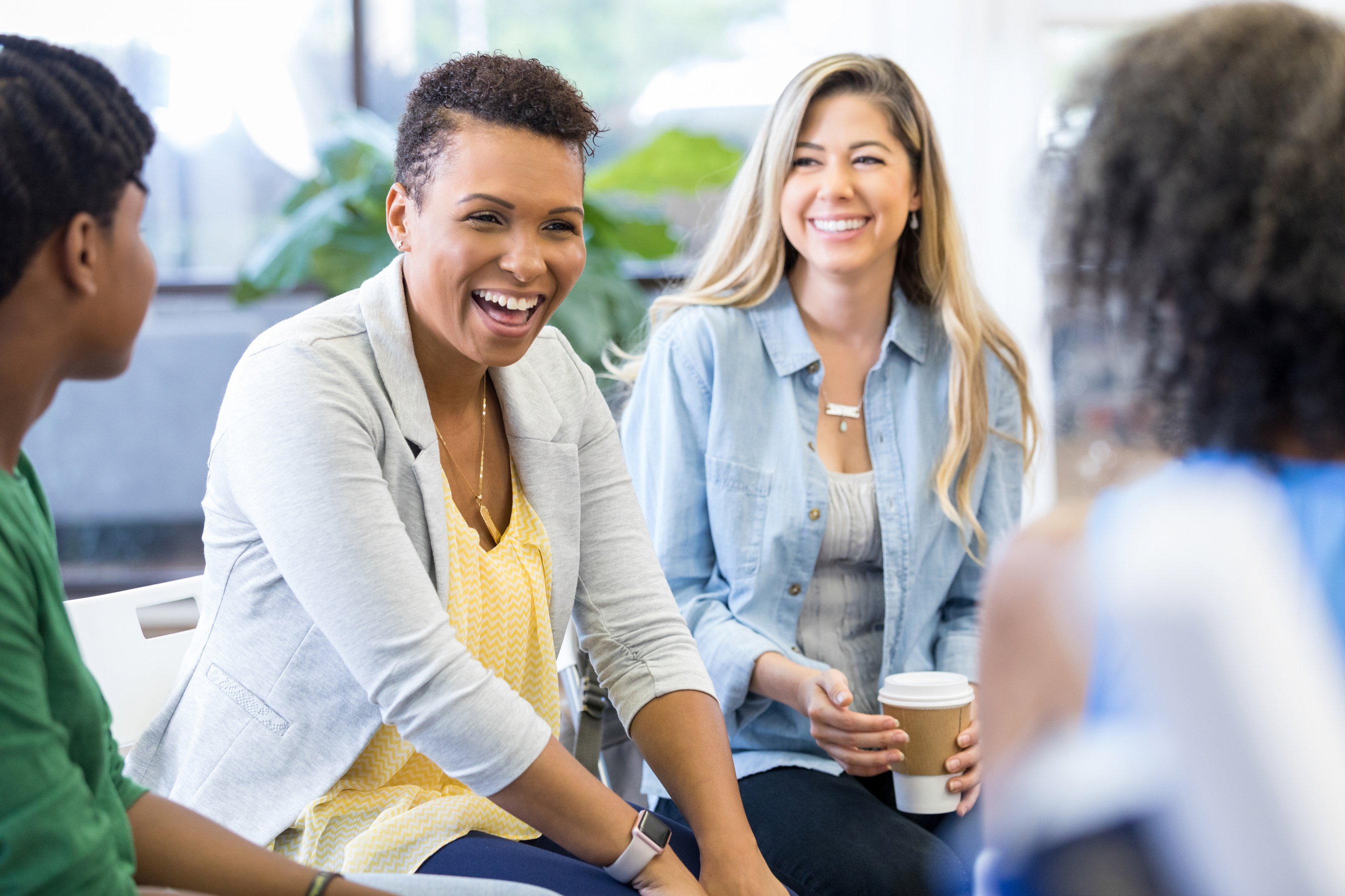 Mid adult mom laughs in group therapy